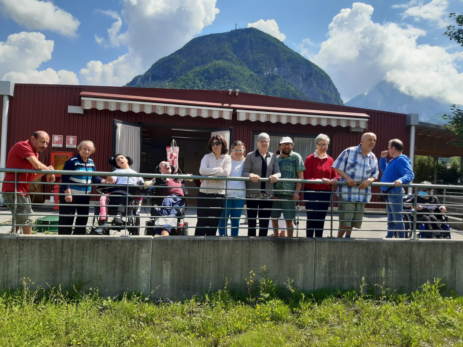 People of the Community on the terrace with the Carnic mountains in the background