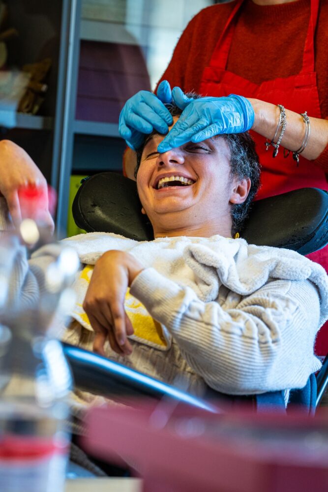 Una persona accolta sorride accanto a un’operatrice